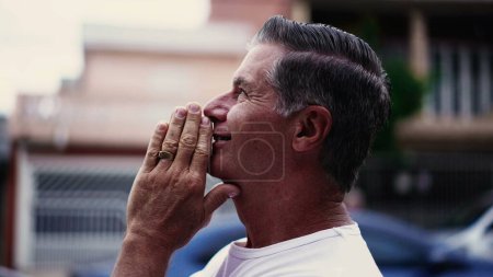 Photo for Devout Senior Man Praying on Street, Smiling Skyward with Hope and Faith. Person feeling GRATITUDE - Royalty Free Image
