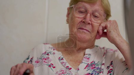 Foto de Pensativo jubilado anciana madura en casa en profunda reflexión reflexiva. Mujer anciana recordando recuerdos pasados mientras pensaba con la mano en la mejilla - Imagen libre de derechos