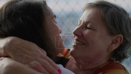 Téléchargez les photos : Joyeuse grand-mère embrassant et embrassant un membre de la famille. Femme âgée embrassant petit-enfant, réunion authentique - en image libre de droit