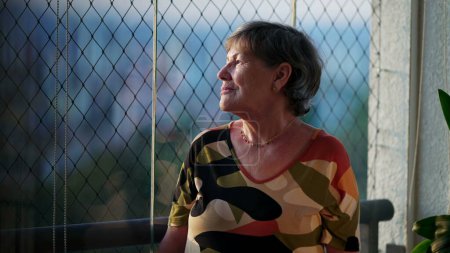 Téléchargez les photos : Moments d'introduction des réflexions solitaires des femmes âgées par la fenêtre, Faire place à la vision de la ville-DD - en image libre de droit