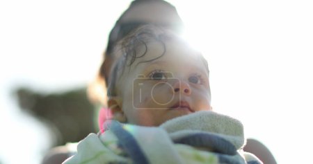 Foto de Niño después de la piscina. Madre sosteniendo al bebé afuera en el resplandor de la lente de luz solar después de nadar - Imagen libre de derechos