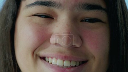 Foto de Joyful Eyes of Young Asian Woman, Macro Close-Up Revealing Detail in a Diverse Female _ s Smile (en inglés). Crystal Clear Enfoque en un sujeto radiante en sus 20 años - Imagen libre de derechos