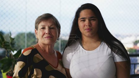 Téléchargez les photos : Portrait générationnel d'une grand-mère et d'une petite-fille diverses posant à la caméra avec une expression confiante - en image libre de droit