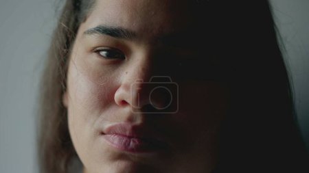 Foto de Cara de cerca de una joven étnicamente diversa que mira a la cámara con expresión seria. Una chica adulta sudamericana brasileña de 20 años - Imagen libre de derechos