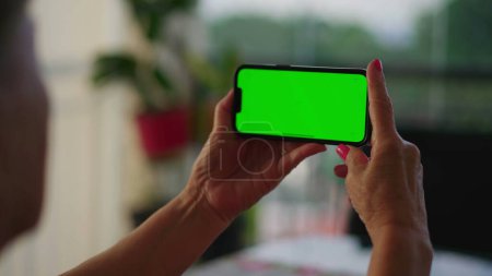 Téléchargez les photos : Personne âgée tenant Smartphone avec écran vert Chroma Key dans la vidéo horizontale. Plus âgé Particulier focalisé sur l'écran de téléphone engageant avec la technologie - en image libre de droit