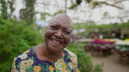 Téléchargez les photos : Portrait d'une femme plus âgée brésilienne en gros plan regardant une caméra debout dans un environnement vert - en image libre de droit