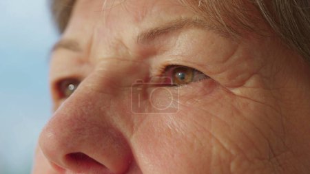 Téléchargez les photos : Pensive senior woman close-up eyes in deep reflection. Détail contemplatif des yeux de dame plus âgée - en image libre de droit