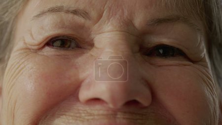 Téléchargez les photos : Femme âgée fermant les yeux en contemplation en macro gros plan. Détail des yeux d'une dame plus âgée avec des rides de sagesse dans la méditation. Personne ouvrant les yeux et souriant - en image libre de droit