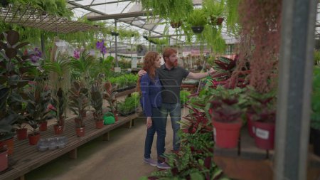 Photo for Young couple shopping for plants at Flower Shop Store. Two people looking for home decoration for new home during weekend activity - Royalty Free Image