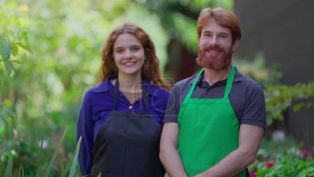 Foto de Retrato de dos jardineros felices en delantales, horticultura Empresarios en medio ambiente verde - Imagen libre de derechos
