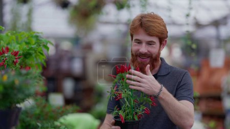 Photo for Joyful Customer Picking Plants at Horticulture Retail Store. Candid Redheaded Male Choosing Flowers at Local Shop - Royalty Free Image