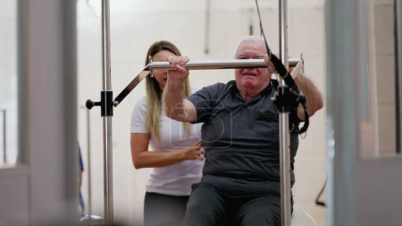 Photo for Female Physiotherapist Assisting Senior Man on Pilates Machine - Royalty Free Image