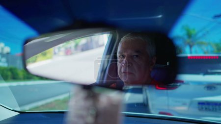 Photo for Senior driver stuck in traffic seen through rearview mirror reflection. Older Person in urban congestion - Royalty Free Image