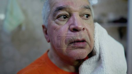 Foto de Cara de cerca del hombre mayor secando la cara después del lavado de rutina en la mañana - Imagen libre de derechos