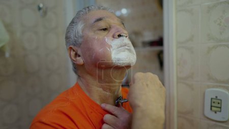 Foto de Hombre mayor afeitándose la barba en el baño, Senior _ s mañana recorte ritual reflectante estilo de vida doméstico - Imagen libre de derechos