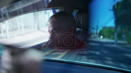 Foto de Hombre mayor tocando la cara y la nariz mientras conduce el coche visto a través del espejo retrovisor reflexión - Imagen libre de derechos