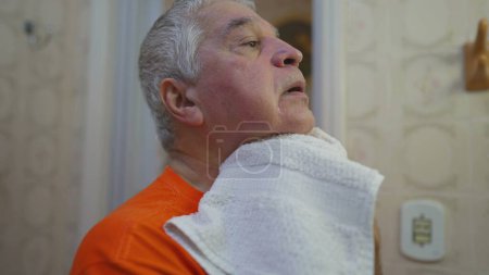 Foto de Hombre mayor secando la cara con toalla después de lavar la rutina de la mañana - Imagen libre de derechos