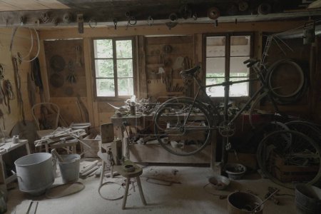 Téléchargez les photos : Magasin en bois encombré avec vélo et outils vintage - en image libre de droit
