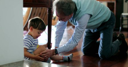 Téléchargez les photos : Grand-père parlant à blesser tout-petit petit-fils - en image libre de droit