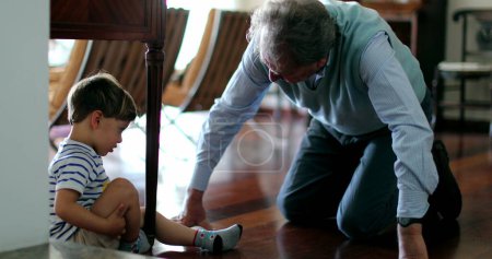 Téléchargez les photos : Grand-père empathique consolant blessé enfant grand-parent atteindre pour enfant larmoyant - en image libre de droit