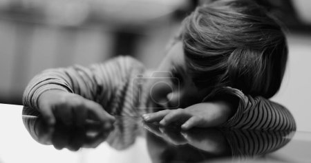 Photo for Depressed child covering face trauma concept in monochrome - Royalty Free Image
