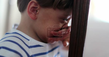 Téléchargez les photos : Enfant pleurant enfant larmoyant essuyant des larmes se sentant bouleversé garçon au sol - en image libre de droit