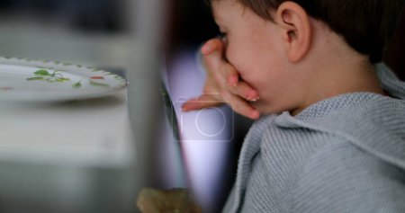 Téléchargez les photos : Enfant essuyant la bouche avec la main enfant frottant visage - en image libre de droit