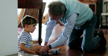 Téléchargez les photos : Grand-père parlant à blesser tout-petit petit-fils - en image libre de droit