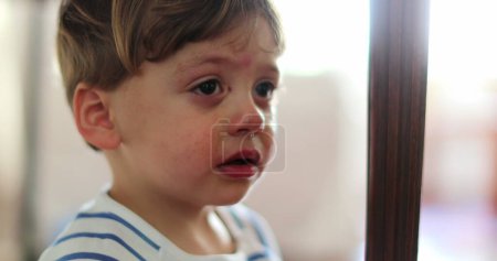 Foto de Niño llorando llorón niño limpiando lágrimas sintiéndose molesto chico castigado - Imagen libre de derechos
