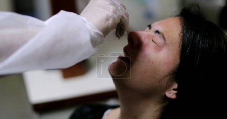 Foto de Mujer que se somete a prueba de nariz COVID procedimiento PCR - Imagen libre de derechos