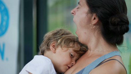 Foto de Madre cansada bostezando sosteniendo al niño exhausto en brazos padres y niños somnolientos - Imagen libre de derechos
