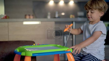 Photo for Child plays with drawing board becoming agitated and frustrated ADHD concept - Royalty Free Image
