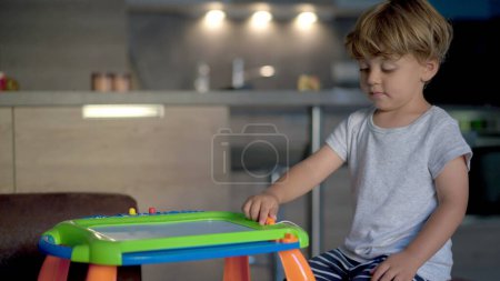 Photo for Child plays with drawing board becoming agitated and frustrated ADHD concept - Royalty Free Image