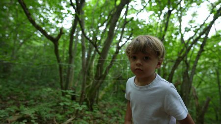 Photo for Child hiking outside on green path kid walking outdoors in the woods - Royalty Free Image
