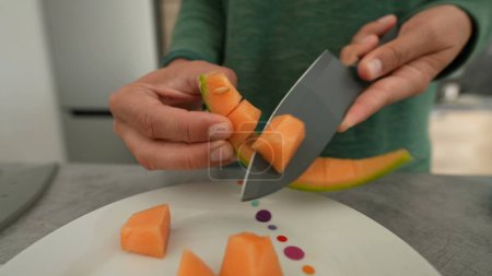 Photo for Hand cutting melon in pieces person cuts fruit - Royalty Free Image