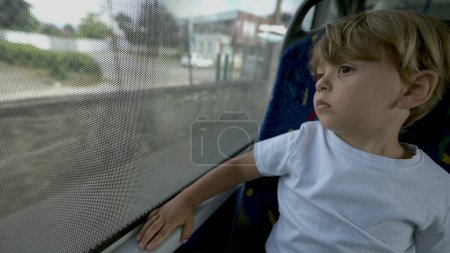 Photo for Child traveling by bus looking out window - Royalty Free Image