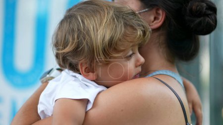 Photo for Exhausted child falling asleep on mother arms during afternoon nap - Royalty Free Image