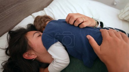 Téléchargez les photos : Parent et enfant embrasser dans le lit du matin - en image libre de droit