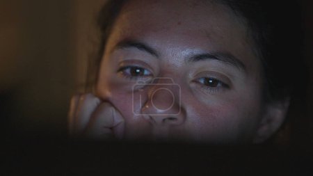Téléchargez les photos : Femme gros plan visage regardant l'écran de l'ordinateur tard dans la nuit - en image libre de droit