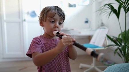 Téléchargez les photos : Enfant jouant de la flûte instrument de musique tout-petit joue de la flûte - en image libre de droit