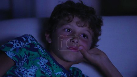 Foto de Niño cara viendo película por la noche - Imagen libre de derechos