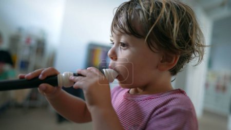 Photo for Baby toddler playing flute child plays musical instrumen - Royalty Free Image