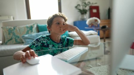 Téléchargez les photos : Enfant navigation internet enfant en utilisant l'ordinateur jeune en utilisant la technologie - en image libre de droit