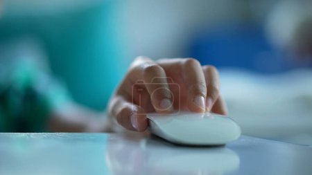 Téléchargez les photos : Main d'enfant en utilisant la souris d'ordinateur en cliquant sur le bouton - en image libre de droit