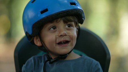 Téléchargez les photos : Un petit garçon heureux portant un casque de vélo portrait visage mains battantes - en image libre de droit