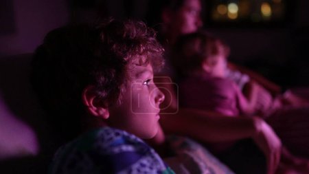 Photo for Child watching television screen at night - Royalty Free Image
