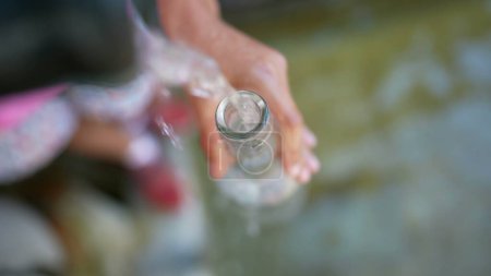 Foto de Llenado de agua de la botella de vidrio del grifo durante el día de verano - Imagen libre de derechos