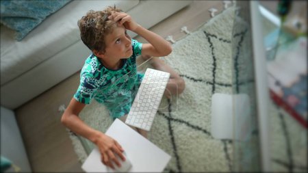 Téléchargez les photos : Jeune garçon utilisant l'ordinateur de bureau navigation sur Internet - en image libre de droit