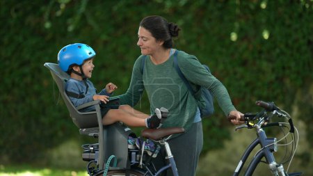 Téléchargez les photos : Mère et enfant moment d'amour ensemble équitation vélo enfant assis sur le siège arrière vélo rire avec maman - en image libre de droit