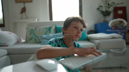 Téléchargez les photos : Jeune garçon utilisant le clavier d'ordinateur et la souris devant l'écran - en image libre de droit